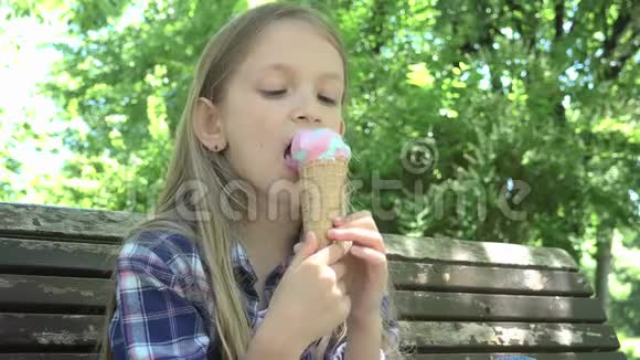 儿童在公园吃冰淇淋儿童在游乐场坐在长凳上放松视频的预览图