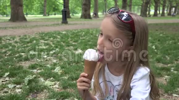 伦敦公园的女孩吃冰淇淋的孩子白金汉宫的孩子在草地上休息视频的预览图
