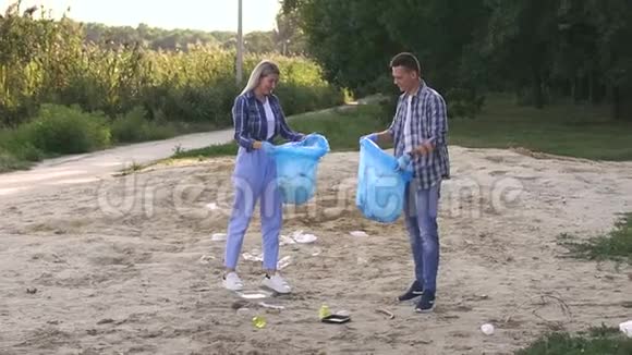 志愿者在河岸的垃圾袋里收集垃圾慢动作视频的预览图