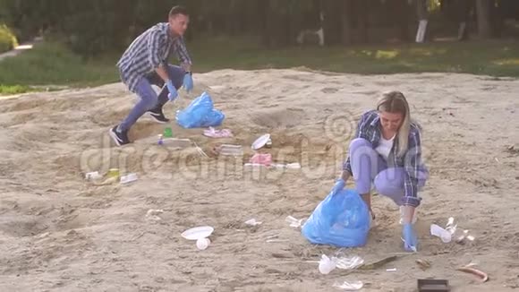 两名青年志愿者在河岸捡垃圾志愿人员概念视频的预览图