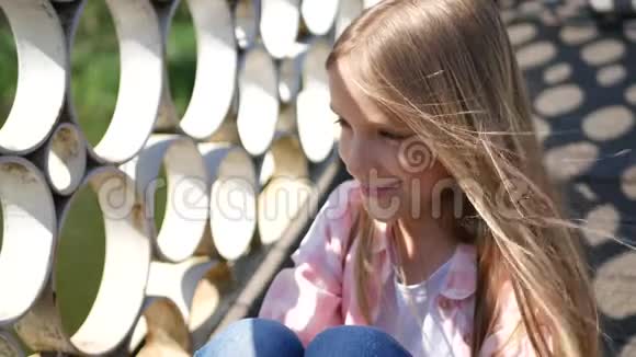 公园里体贴的孩子户外可爱的小女孩无聊的表达孩子的脸视频的预览图