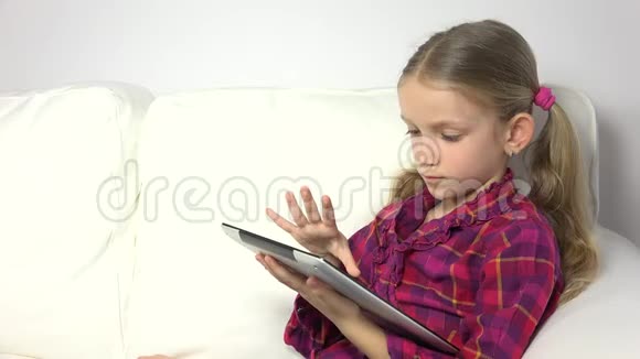 儿童玩平板电脑儿童在沙发上智能手机女孩肖像网络搜索学习4K视频的预览图