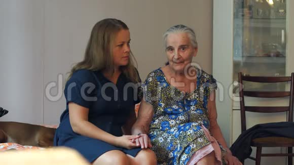 一个年轻的女人在家里和她八十岁的祖母说话视频的预览图