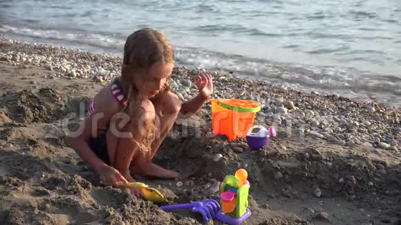 4K孩子在沙滩上玩耍海滩上的儿童冲浪海岸线上的女孩建筑城堡湾视频的预览图