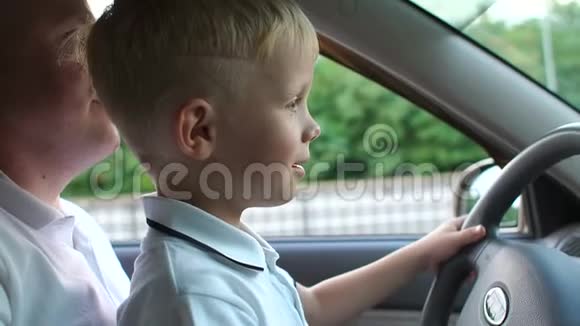一个好奇的五岁男孩和他父亲开着一辆车的特写肖像视频的预览图