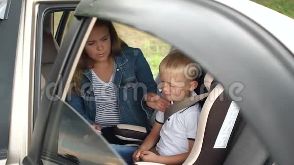 妈妈的特写把小儿子的安全带系汽车座椅上视频的预览图