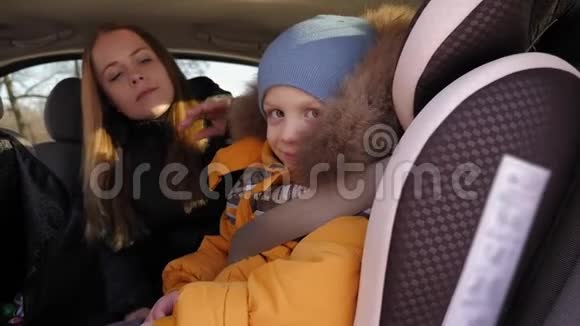 冬天一位母亲用汽车安全带系住儿子视频的预览图