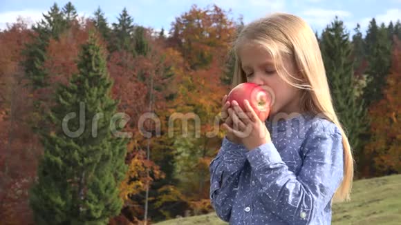 4K童吃苹果水果儿童吃零食肖像女孩秋景景观视频的预览图