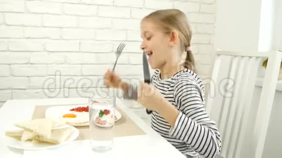 儿童在厨房吃早餐儿童吃煎蛋少女享受蔬菜绿色健康食品视频的预览图