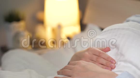 女性手关灯夜幕降临在房间里上床睡觉的概念特写视频的预览图