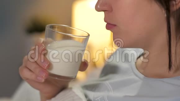 女孩睡觉前从透明玻璃喝牛奶特写视频的预览图
