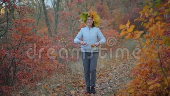 美丽的女人秋天的叶子在头上长出叶子视频的预览图