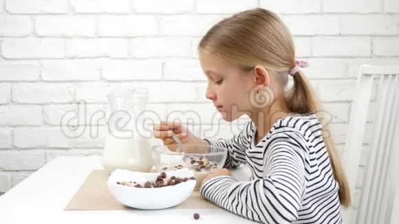 儿童早餐时吃牛奶和谷类食品儿童厨房少女进餐时品尝健康食品营养视频的预览图