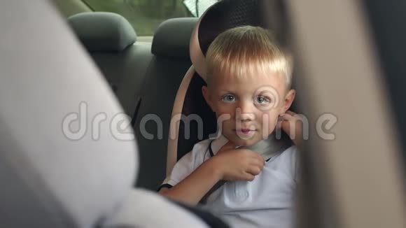 一个男孩的肖像在一个儿童汽车座位在夏季旅行特写视频的预览图