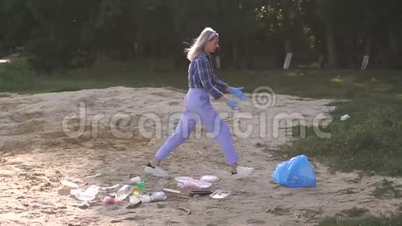 一个女志愿者在海滩上捡垃圾一个女孩正在打扫海滩视频的预览图