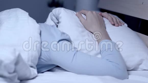 吵闹的邻居噩梦的概念女孩晚上独自躺在床上用枕头遮住她的头特写视频的预览图