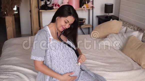 孕妇听婴儿心跳用听诊器放在她的腹部视频的预览图