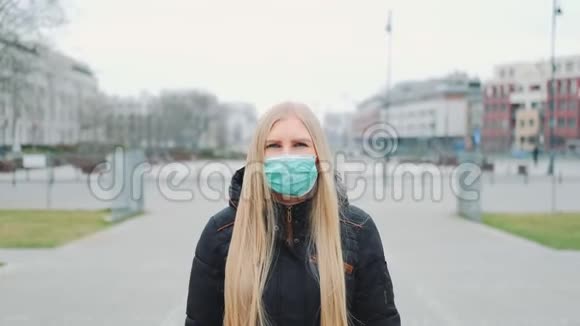 冠状病毒大流行戴着医疗面具的金发女人走在街上视频的预览图