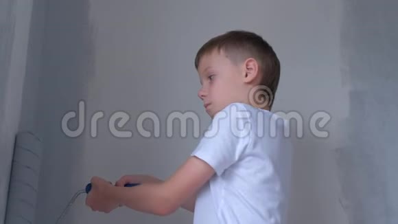小男孩画家正在他的房间里用油漆滚筒粉刷墙壁视频的预览图