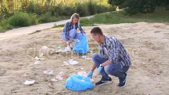 两名青年志愿者在河岸捡垃圾志愿人员概念视频的预览图