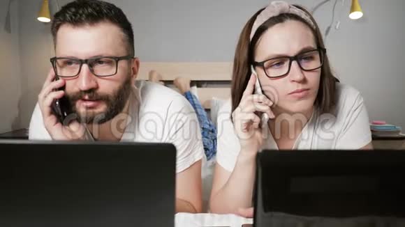 在家工作自由职业概念丈夫和妻子躺在卧室的床上同时工作在笔记本电脑上打字视频的预览图