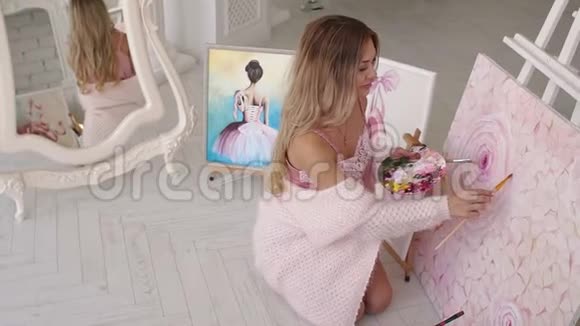 温柔的女孩艺术家在家里画粉红色的花坐在地板上视频的预览图