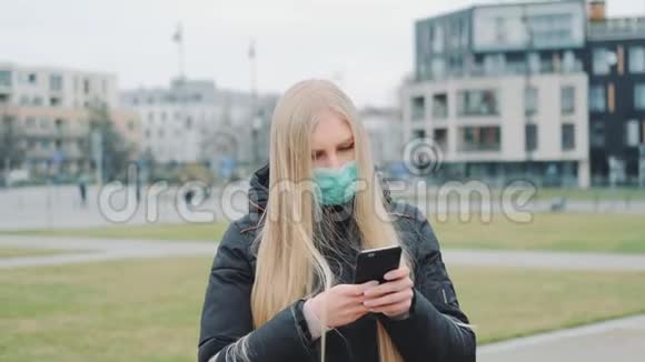 中等镜头的女孩戴着医疗面具在街上读到关于冠状病毒疾病的突破性消息视频的预览图