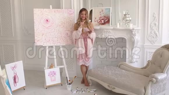 一幅穿着粉红色毛衣的女孩的肖像她的手里拿着一个调色板在一个艺术工作室视频的预览图