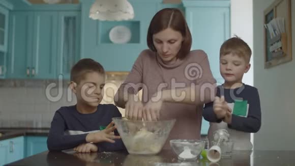 快乐的一家人在做饼干的时候玩面粉孩子们帮妈妈揉面团玩面粉视频的预览图