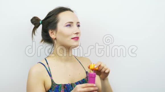 有趣的女孩用明亮的粉红色化妆吹泡泡美丽的女人吹肥皂泡有乐趣的女人我是个好姑娘视频的预览图