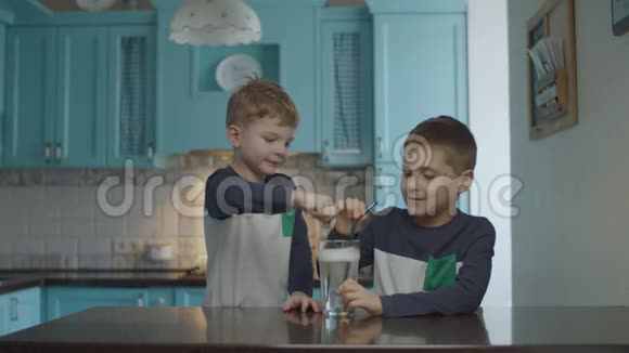 孩子们通过喝吸管喝带有气泡的自制苏打水兄弟们在厨房里喝饮料视频的预览图