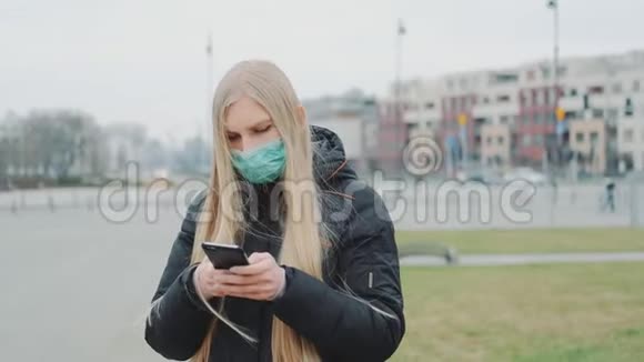年轻女性戴着医用口罩在街上宣读关于冠状病毒疾病的突破性消息视频的预览图