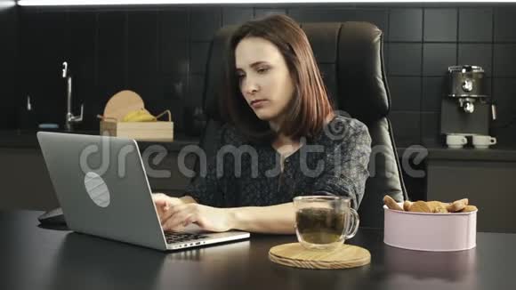 年轻的女性自由职业者头痛在家里用笔记本电脑工作在厨房做笔记本的女人很不高兴不快乐的女性视频的预览图