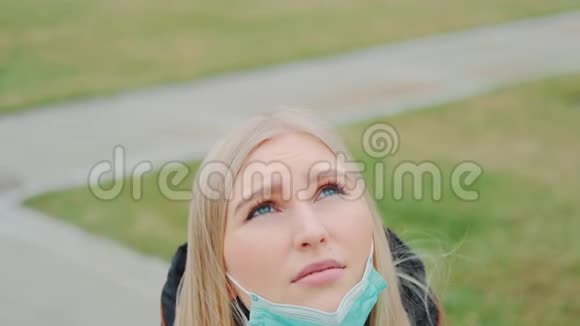 年轻女性仰望天空戴上医用面具视频的预览图