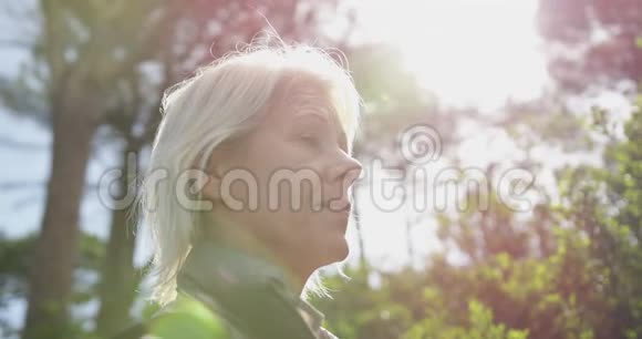 森林中老年妇女的侧景视频的预览图
