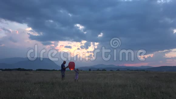 4K中国提灯欢乐一家人玩户外日落山景视频的预览图