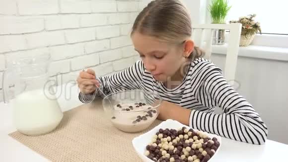 孩子在早餐时吃牛奶和谷类食品孩子在厨房青少年女孩在用餐时品尝健康食品营养视频的预览图