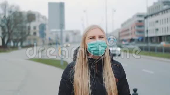 戴着医用冠状病毒面具的妇女在街上行走视频的预览图