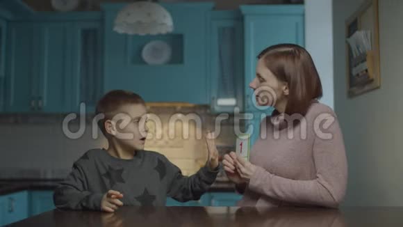 妈妈在家里教自闭症孩子带卡片患有自闭症的孩子的学习数字与母亲出示教育卡视频的预览图