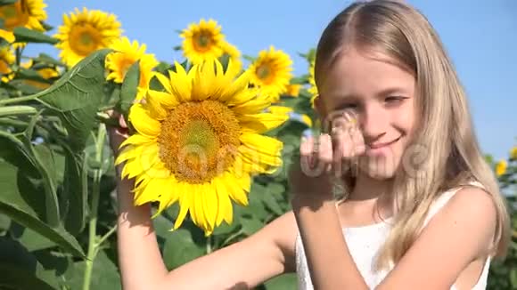 向日葵农业田里的农民孩子十几岁的女孩在农业丰收中玩耍的孩子视频的预览图