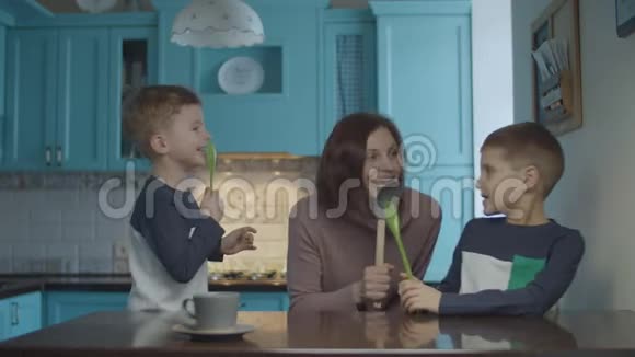 快乐的家庭跳舞和唱歌进入厨房就像麦克风在家庭蓝色厨房女人跳舞视频的预览图