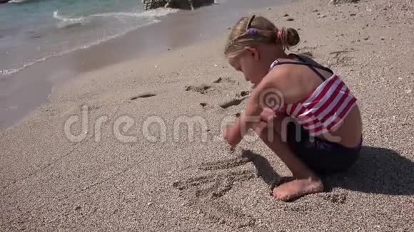 4K孩子在沙滩上画画孩子在海边玩耍女孩在海浪中洗澡视频的预览图