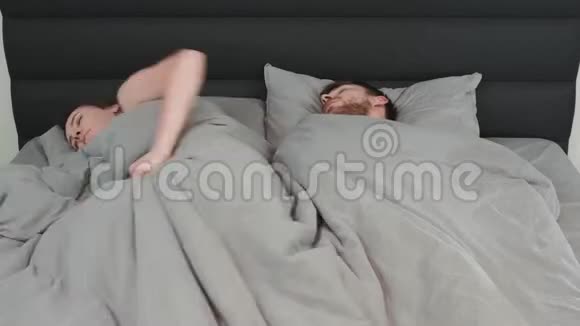 年轻的女人和男人睡在床上时间流逝一对夫妇躺在床上睡觉已婚快乐的夫妇视频的预览图