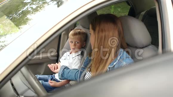 母子正坐在车前座孩子吃糖果视频的预览图
