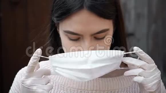 年轻女子把医用口罩放在外面防止冠状病毒COVID19视频的预览图