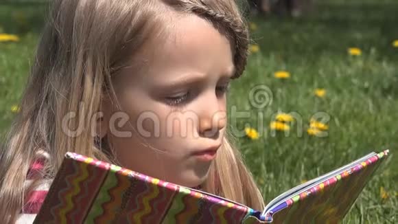 儿童在公园草地上阅读儿童肖像自然户外女孩面读视频的预览图