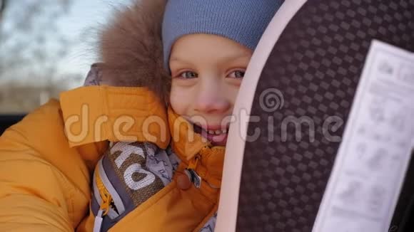 小男孩坐在儿童安全座椅上穿着冬天的夹克视频的预览图