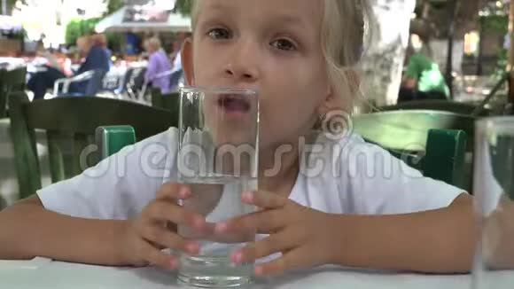 4K小子喝水无聊的小女孩肖像脸在餐厅玩水玻璃视频的预览图