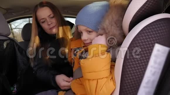 冬天母亲在车里用安全带系住孩子视频的预览图