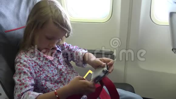 4K儿童乘坐飞机旅行儿童放置安全带女孩乘坐飞机安全带视频的预览图